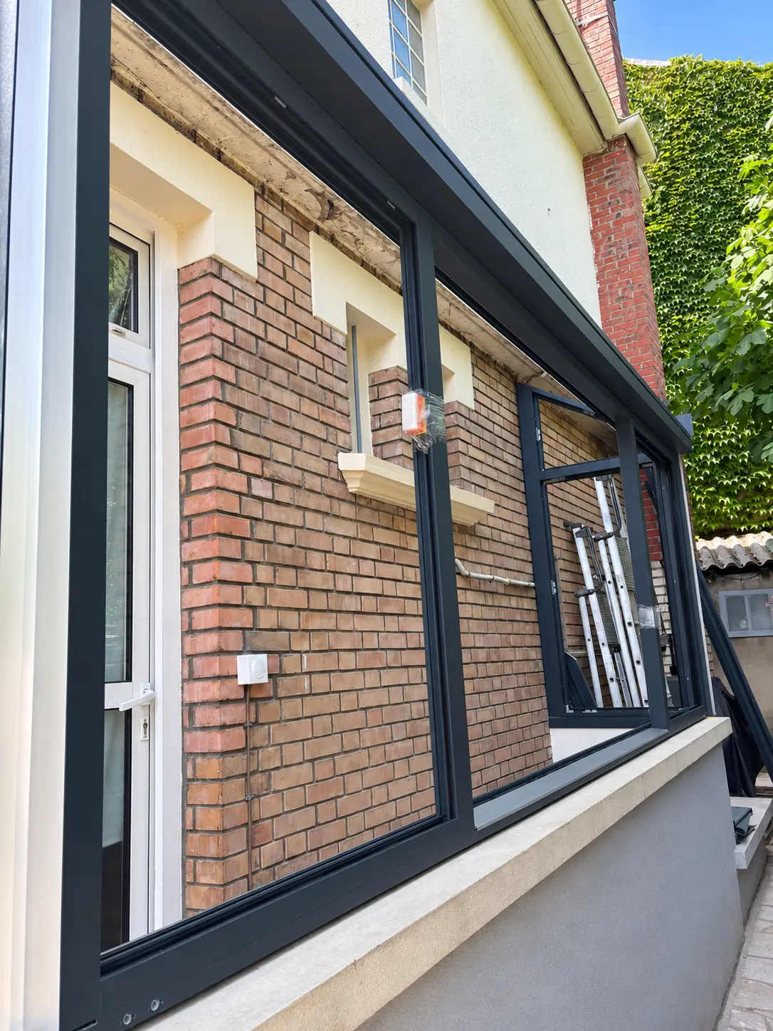 Nouvelle structure sombre de véranda en cours de pose